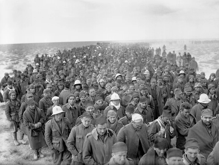 Italian prisoners of war captured during the Battle of Bardia march into captivity following the British offensive during Operation Compass, January 1941.