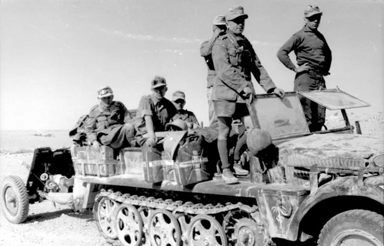 Afrika Korps Sd.Kfz. 10 half-track towing a 3.7 cm Pak 36 anti-tank gun across the North African desert during Operation Sonnenblume, 1941