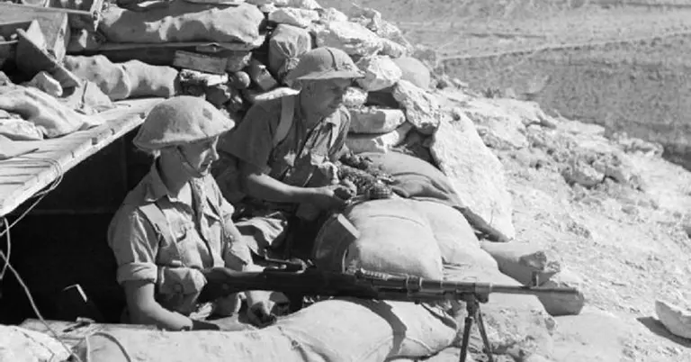 Australian 9th Division soldiers man a Bren light machine gun from a sandbagged defensive position at Tobruk during the Siege of Tobruk, 1941